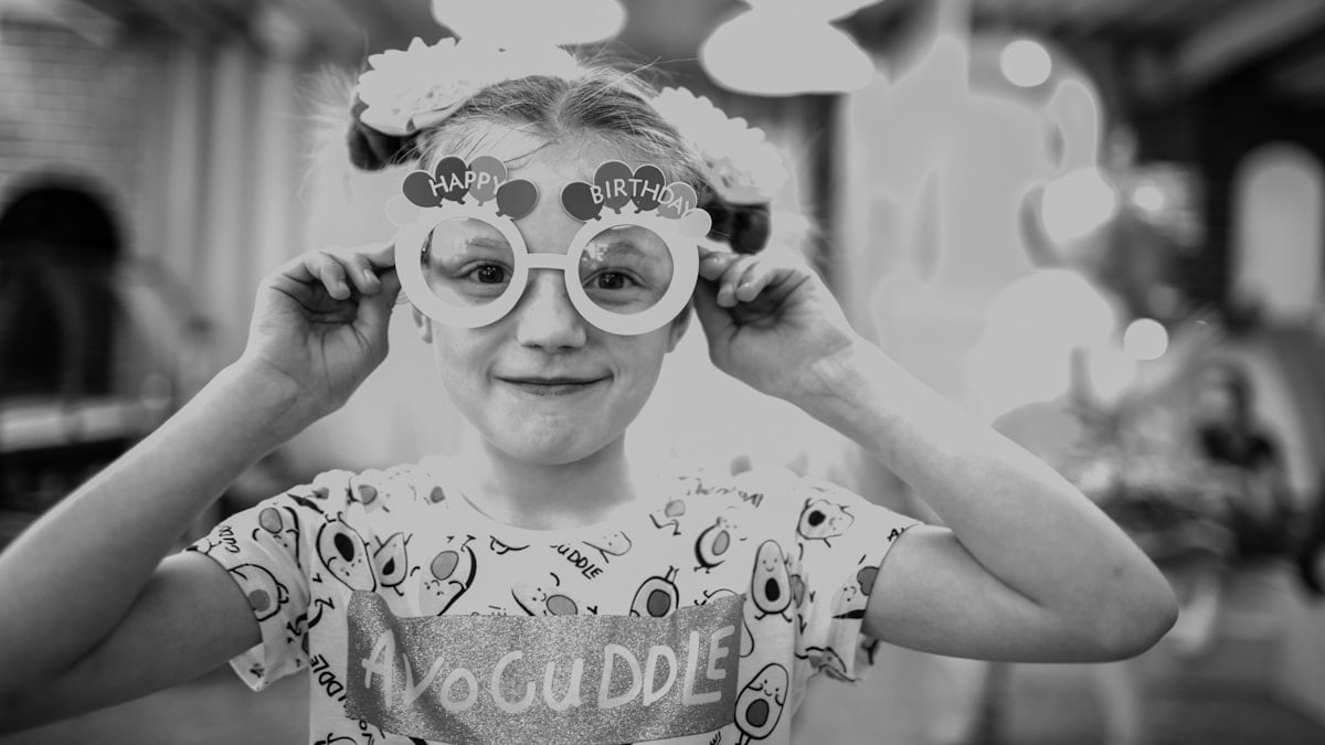 a little girl with some glasses on her face