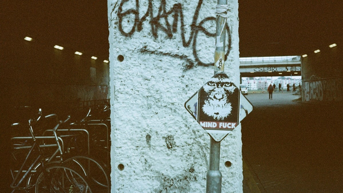 Graffiti and street art decorate a tunnel entrance.